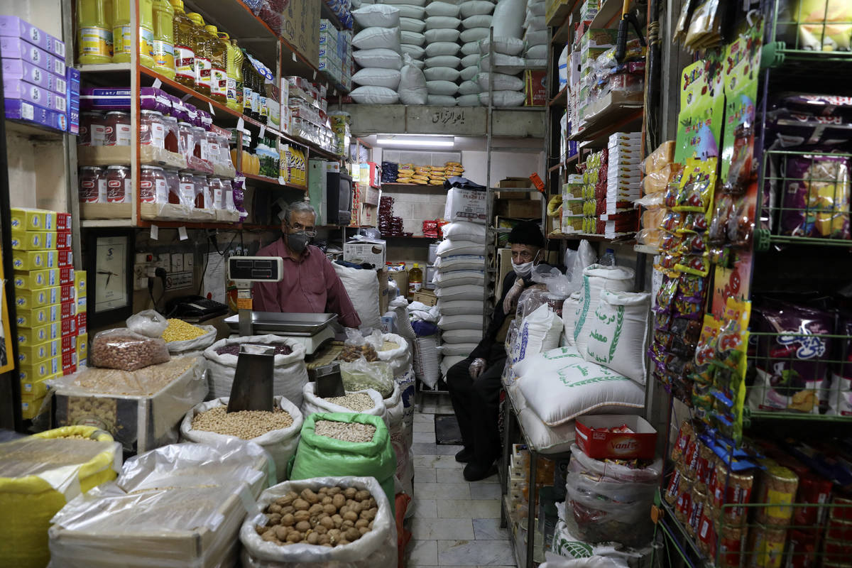 Shopkeepers wearing protective face masks and gloves to help prevent the spread of the coronavi ...