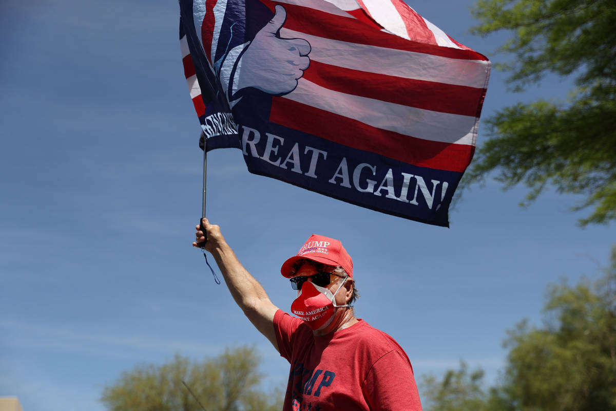 John Welsh of Henderson holds up a flag during a Fight For Nevada rally outside of the Grant Sa ...