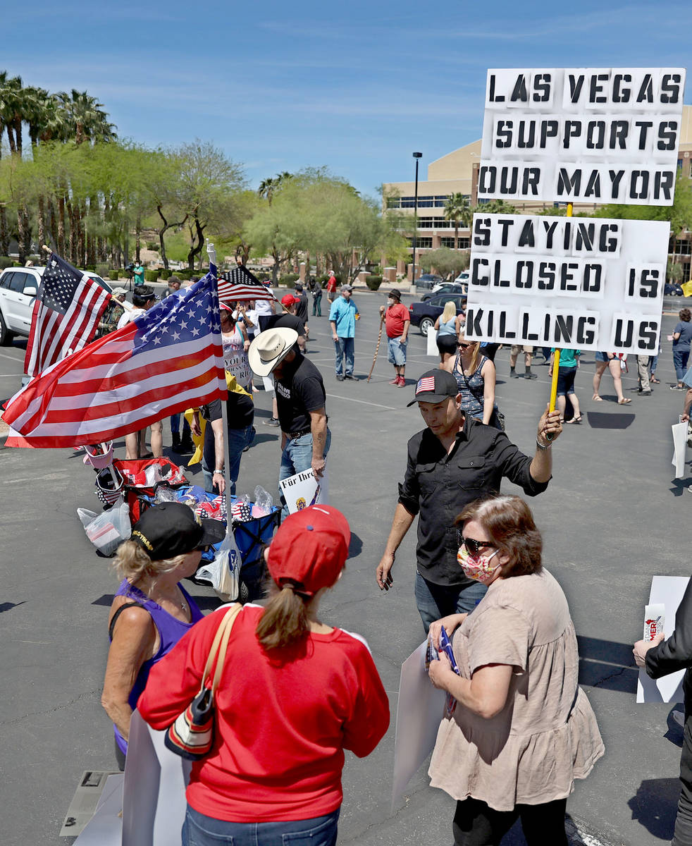 Harold Reese holds up a sign while talking to people during a Fight For Nevada rally outside of ...