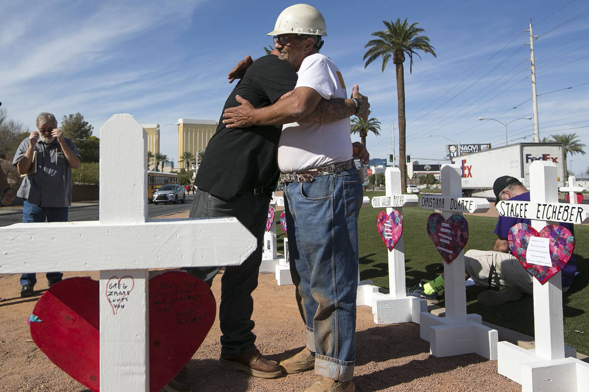 Cross maker Greg Zanis, right, gets a hug from Mike Warino, brother of Oct.1 shooting victim He ...