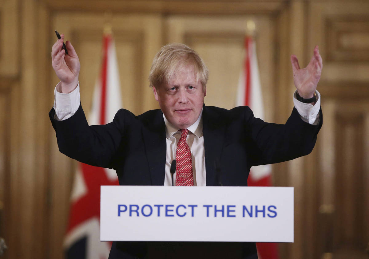 FILE - In this Sunday March 22, 2020 file photo British Prime Minister Boris Johnson gestures d ...