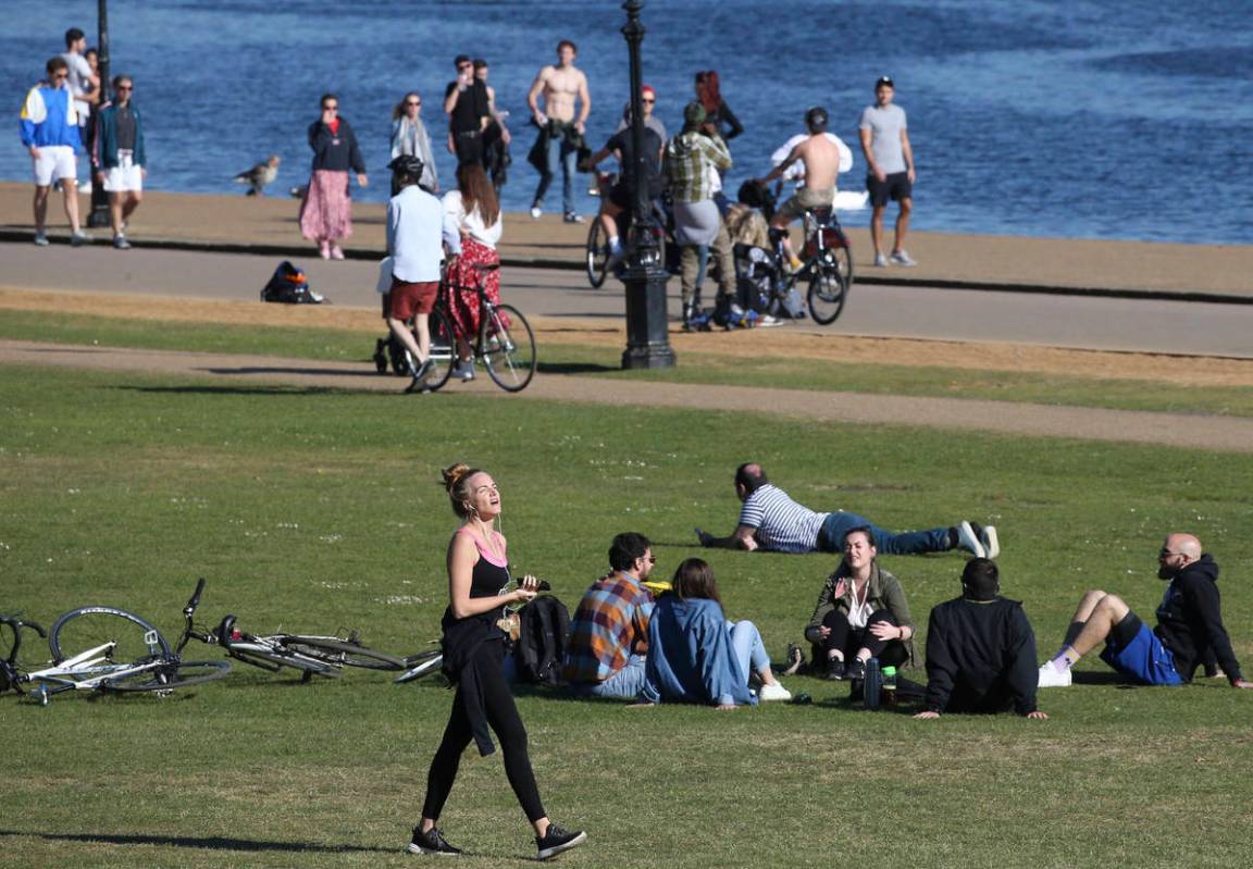 People walk, exercise and relax by the Serpentine in Hyde Park as the UK continues its lockdown ...