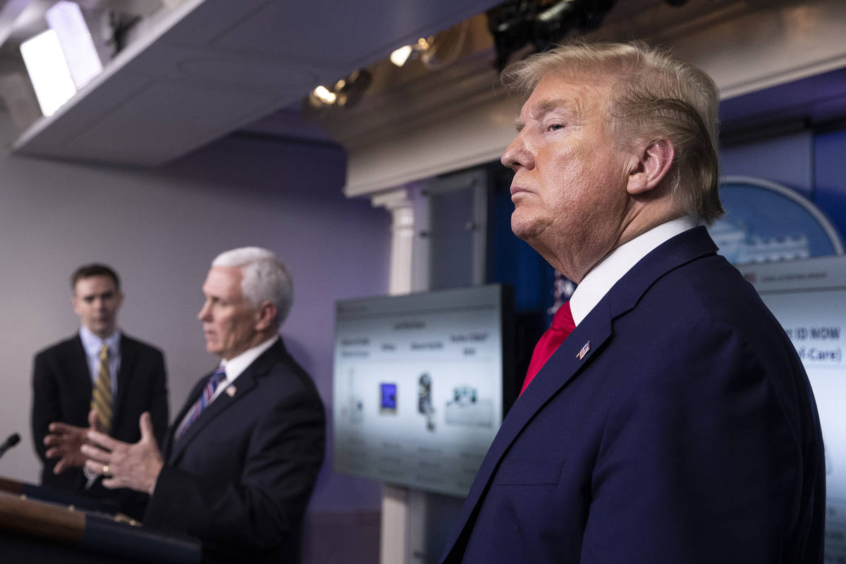 FILE - In this April 20, 2020, file photo President Donald Trump stands as Vice President Mike ...