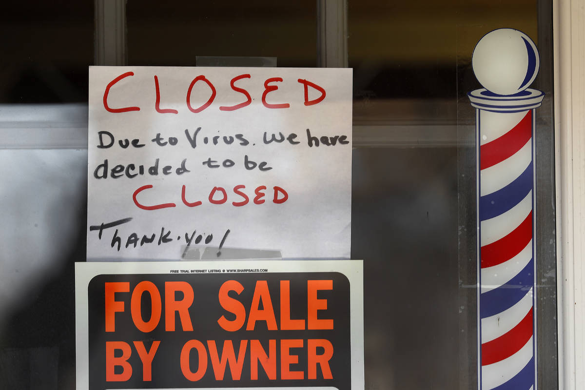 In this April 2, 2020 file photo, "For Sale By Owner" and "Closed Due to Virus" signs are displ ...