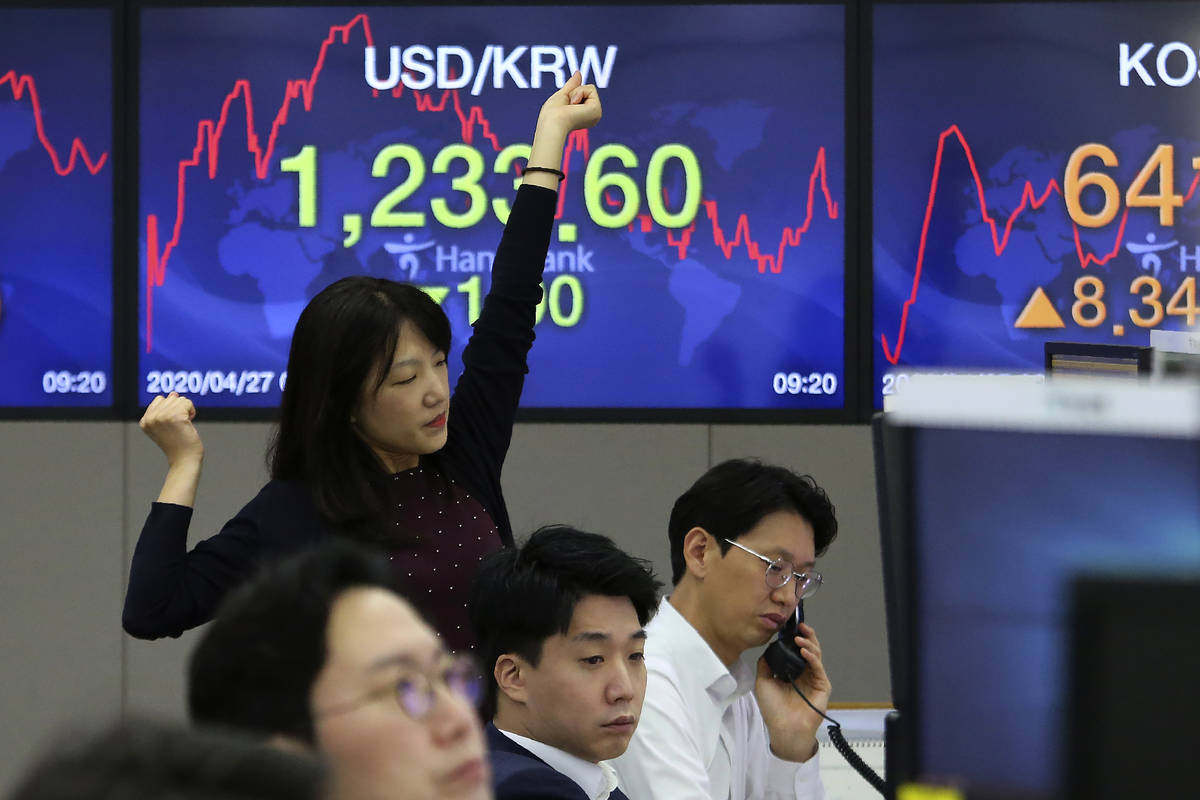 A currency trader stretches at the foreign exchange dealing room of the KEB Hana Bank headquart ...