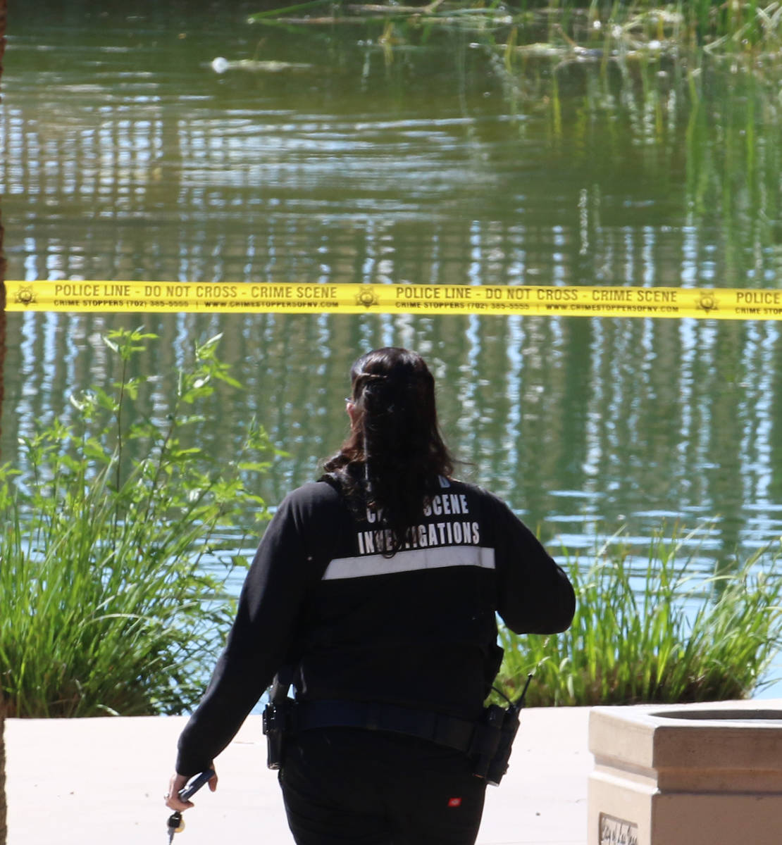 A Las Vegas police crime scene investigation officer works at the scene after a man's body was ...
