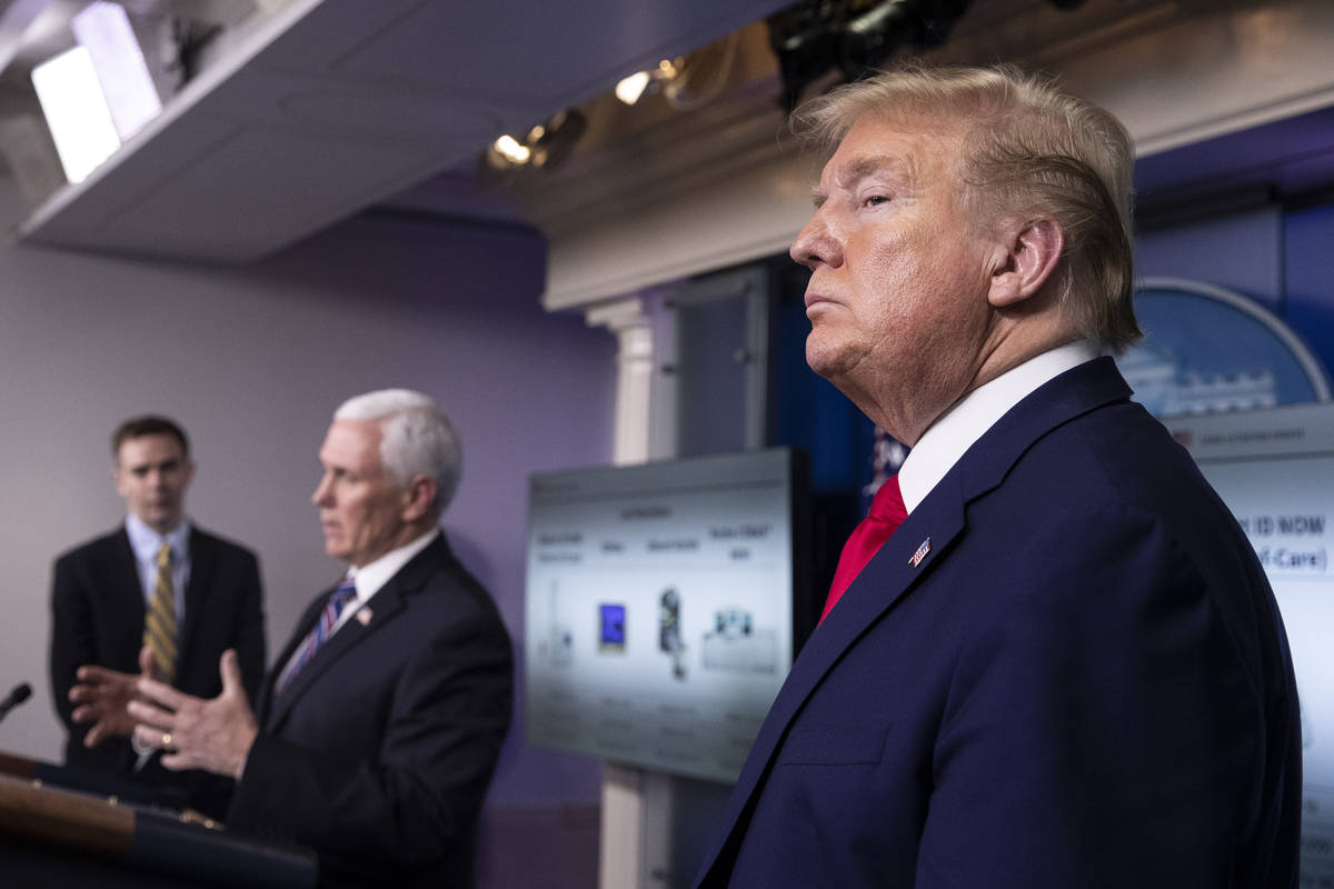 President Donald Trump stands as Vice President Mike Pence speaks about the coronavirus in the ...