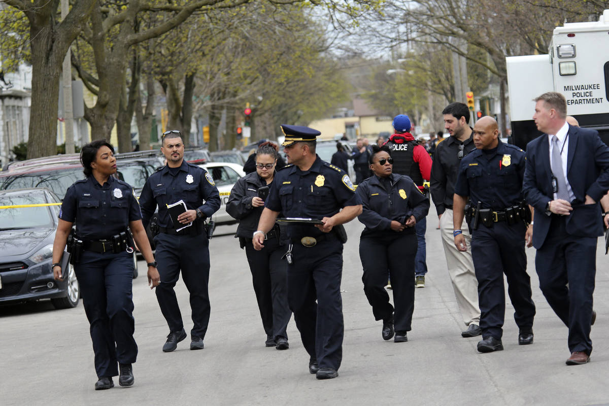 Milwaukee Police Chief Alfonso Morales, center, makes his way with his staff to give a news con ...