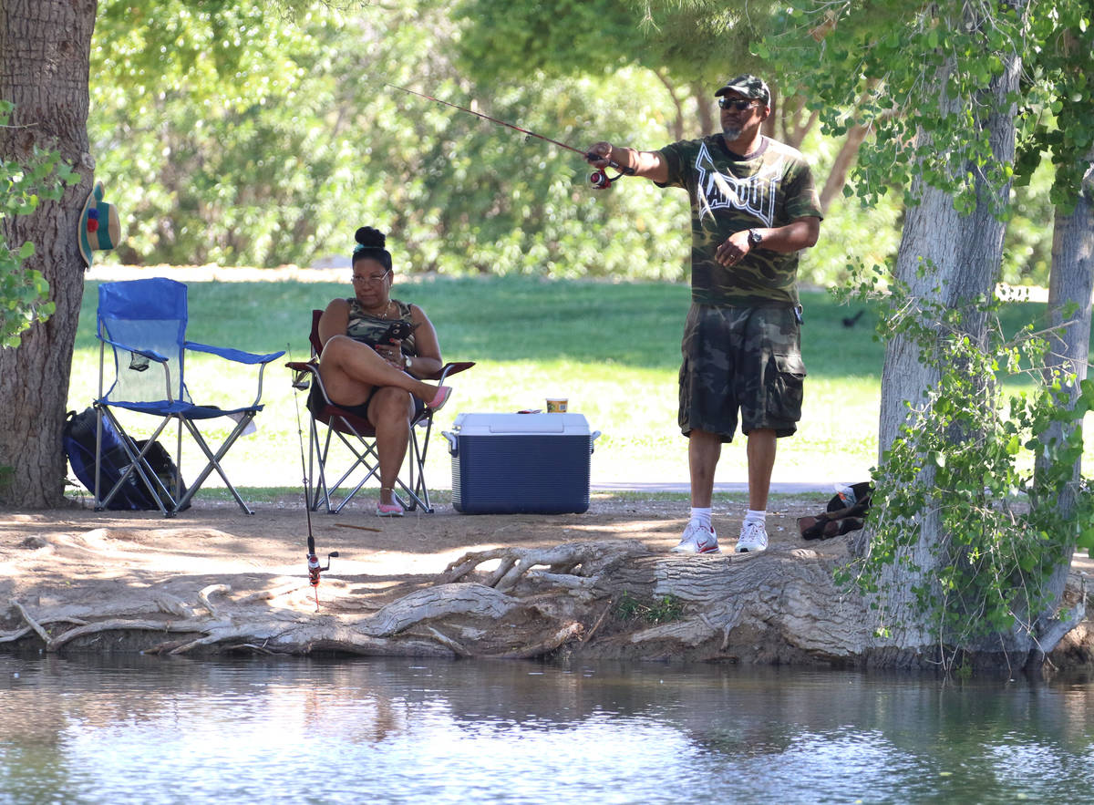 Earl Wood, right, fishes as his wife, Elisa, looks on at Floyd Lamb Park Tuesday, April 28, 202 ...