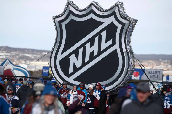 Fans pose below the NHL league logo at a display outside Falcon Stadium before an NHL Stadium S ...