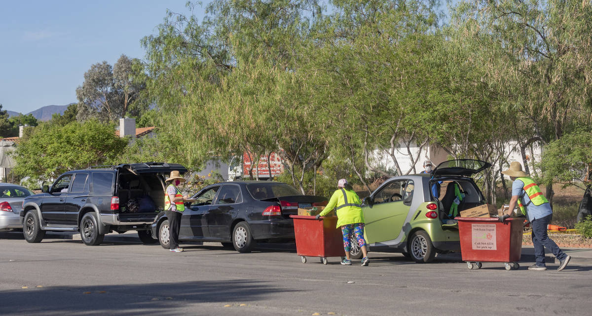 A line of cars stretching one mile down Palo Verde Drive, collect meals from St. Therese Center ...