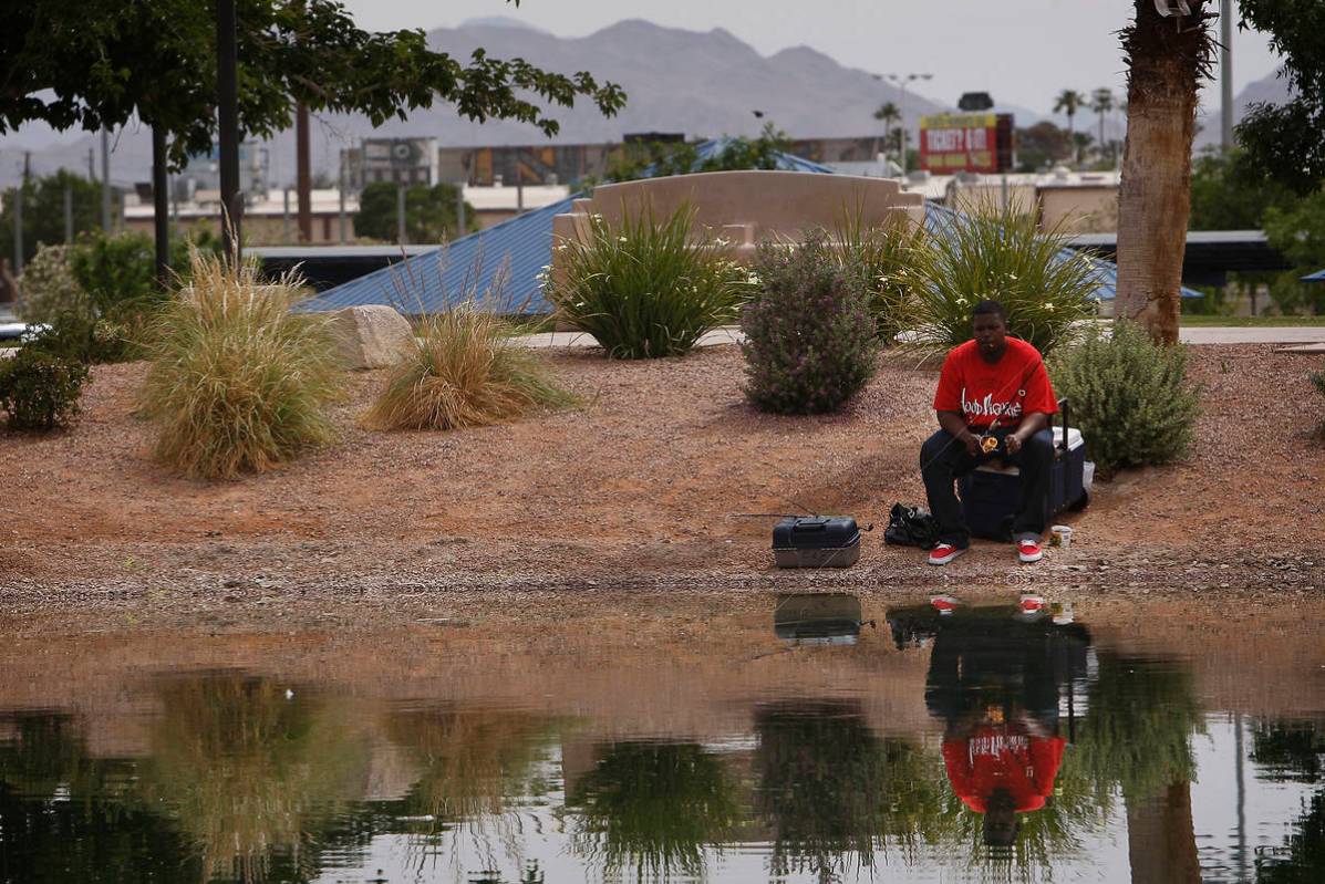 Antonio Asberry fishes in the freshly stocked pond at Lorenzi Park in Las Vegas on Friday, May ...