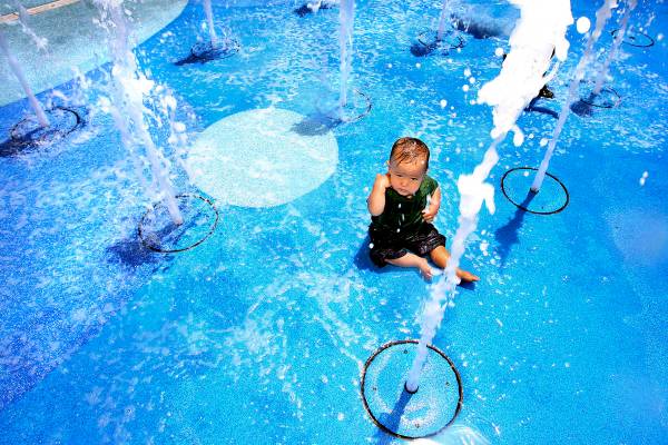 Eleven-month-old Parker Gurdison sits amid cooling columns of water at the Town Square water fo ...