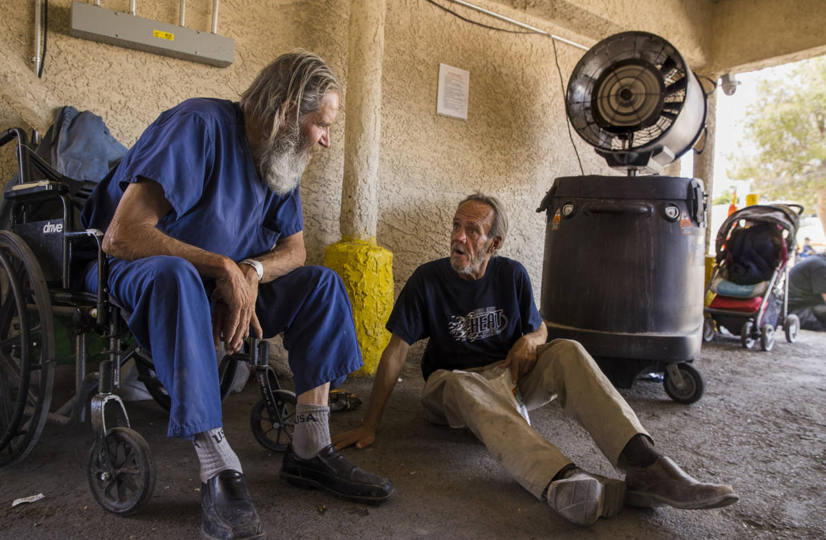 Clients Gregory Porath, left, and Gary Moore stay cool under an overhang with a misting fan wit ...