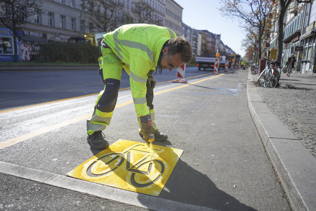 Employee Alexander of the Zeppelin company marks a temporary cycle lane on the Kottbusser Damm ...