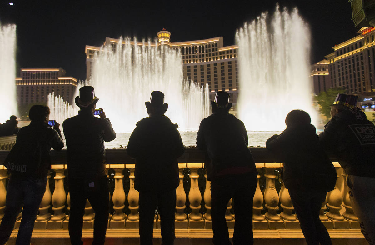 People enjoy the Bellagio fountain show on the Strip on Tuesday, Dec. 31, 2019, in Las Vegas. ( ...