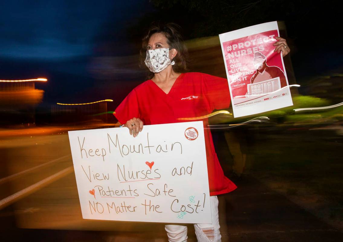 Critical care nurse Marian Madsen holds a sign advocating for better protection, testing and be ...