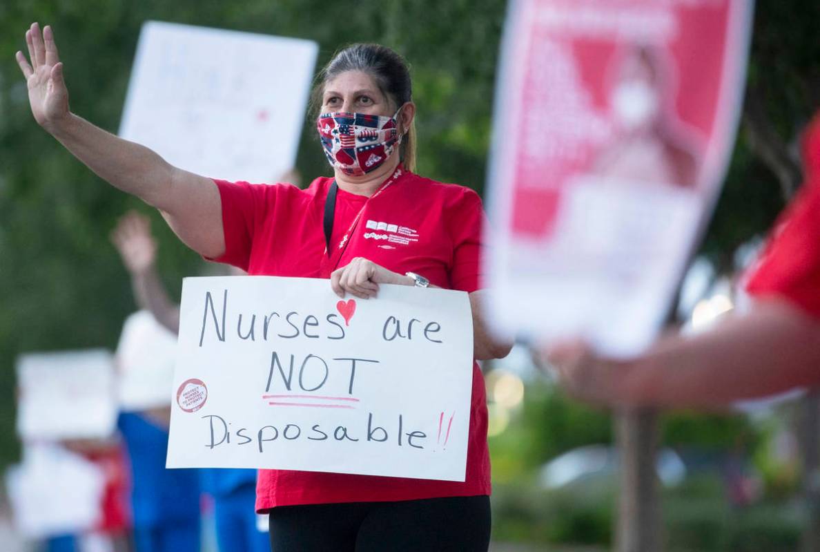 Recovery room nurse Lauren Elfman holds a sign advocating for better protection, testing and be ...