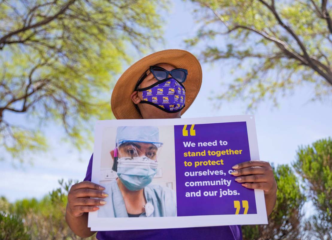 Zavia Norman, private sector vice president of Local SEIU 1107, holds a sign in protest of unsa ...