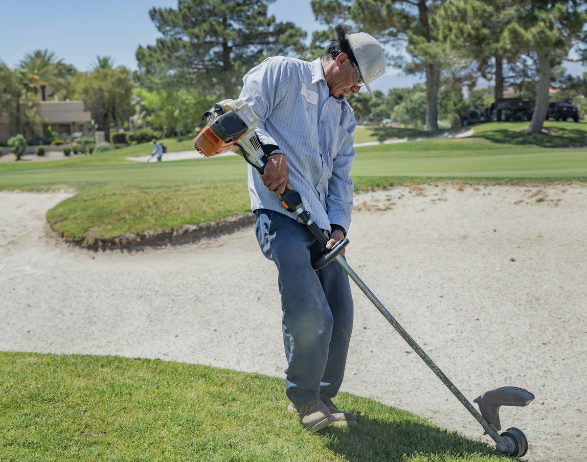 Groundskeeper Jose Gallegos edges the sand bunkers in preparetion for the opening of the Spanis ...
