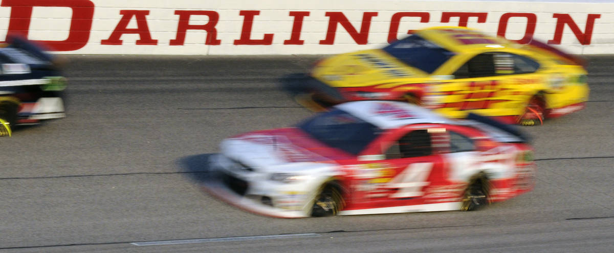FILE - In this April 12, 2014, file photo, Kevin Harvick (4) and Joey Logano (22) race during a ...