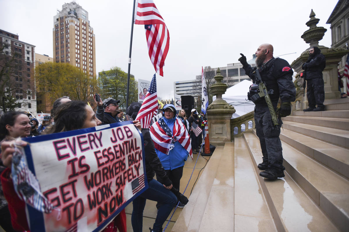 Members of the Michigan Liberty Militia, including Phil Robinson, right, join protesters at a r ...