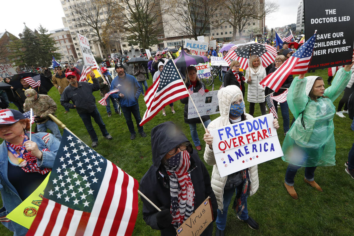 Protesters rally at the State Capitol in Lansing, Mich., Thursday, April 30, 2020. Hoisting Ame ...