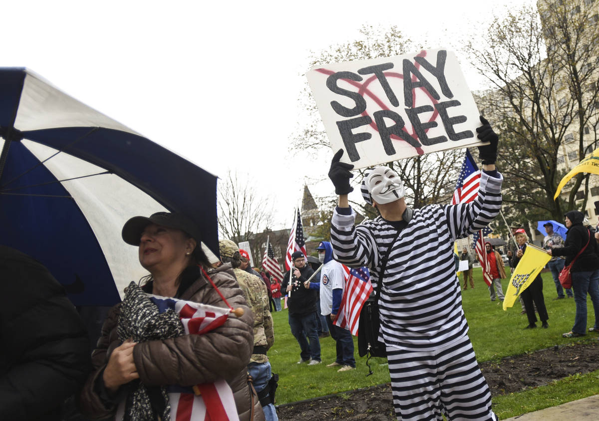 Protesters rally at the state Capitol in Lansing, Mich., Thursday, April 30, 2020. Hoisting Ame ...