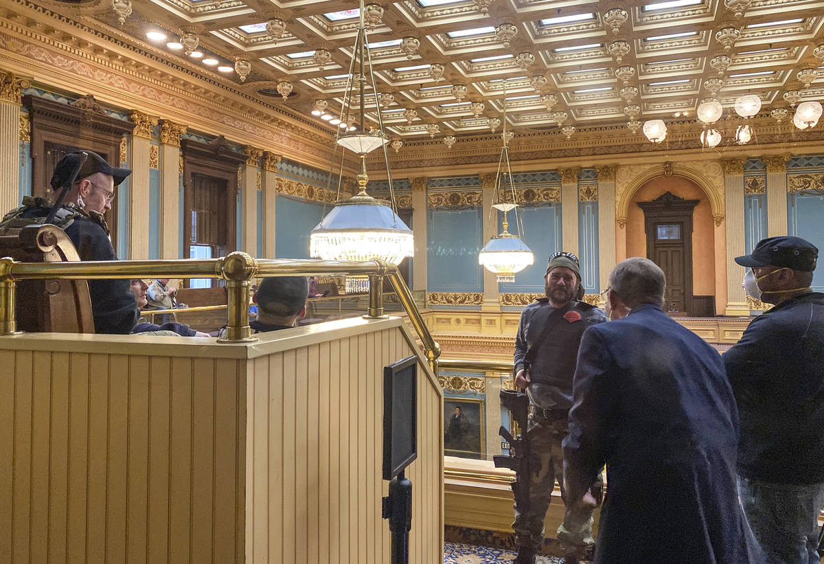 Armed protesters stand in the gallery of the Michigan State Senate chambers at the State Capito ...