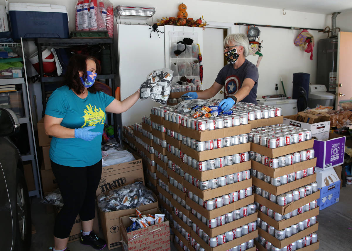 Jeana Taylor, left, founder of Vegas Community Pantry, and her husband Scott check out items af ...