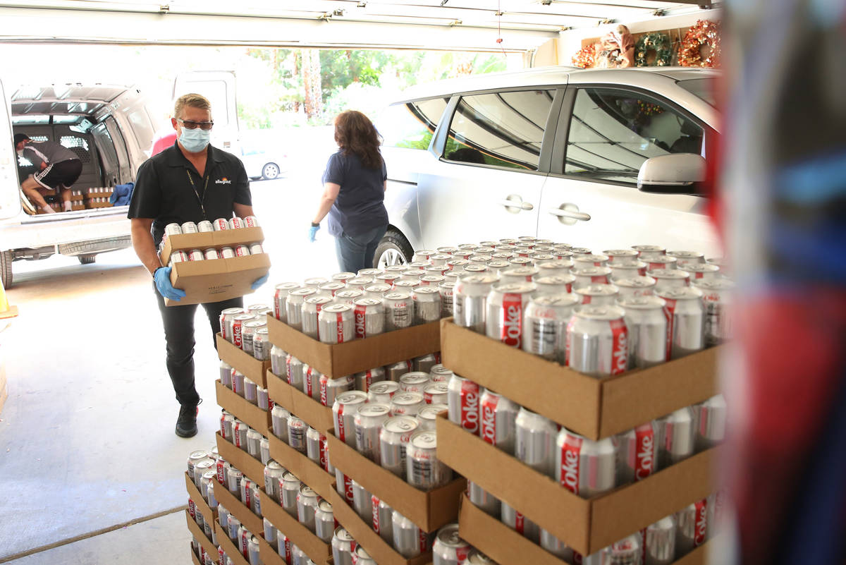 Darren Ranew, facility chief engineer at Allegiant Air, unloads cases of Diet Coke into Jeana T ...