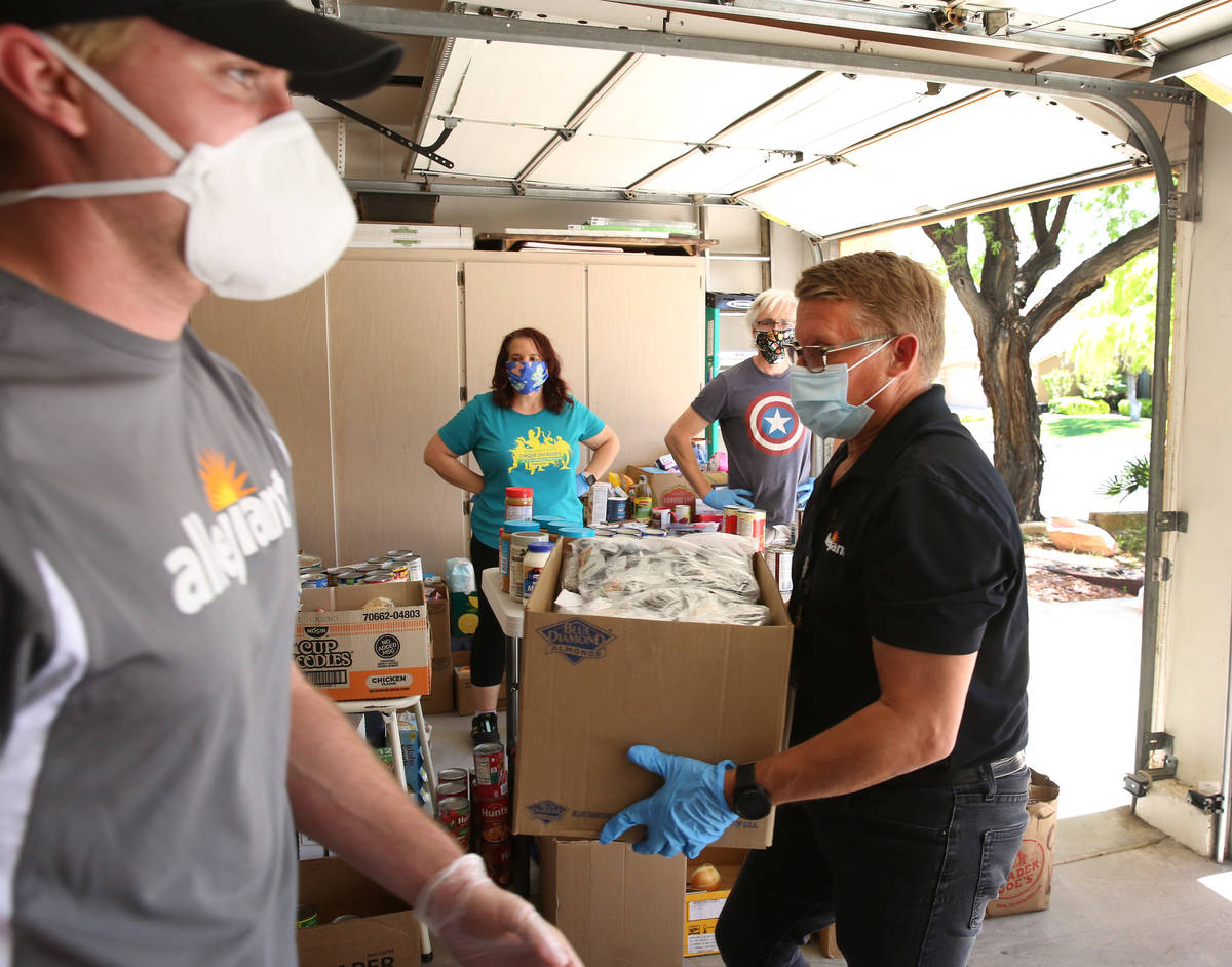 Jeana Taylor, second left, founder of Vegas Community Pantry, and her husband Scott, second rig ...