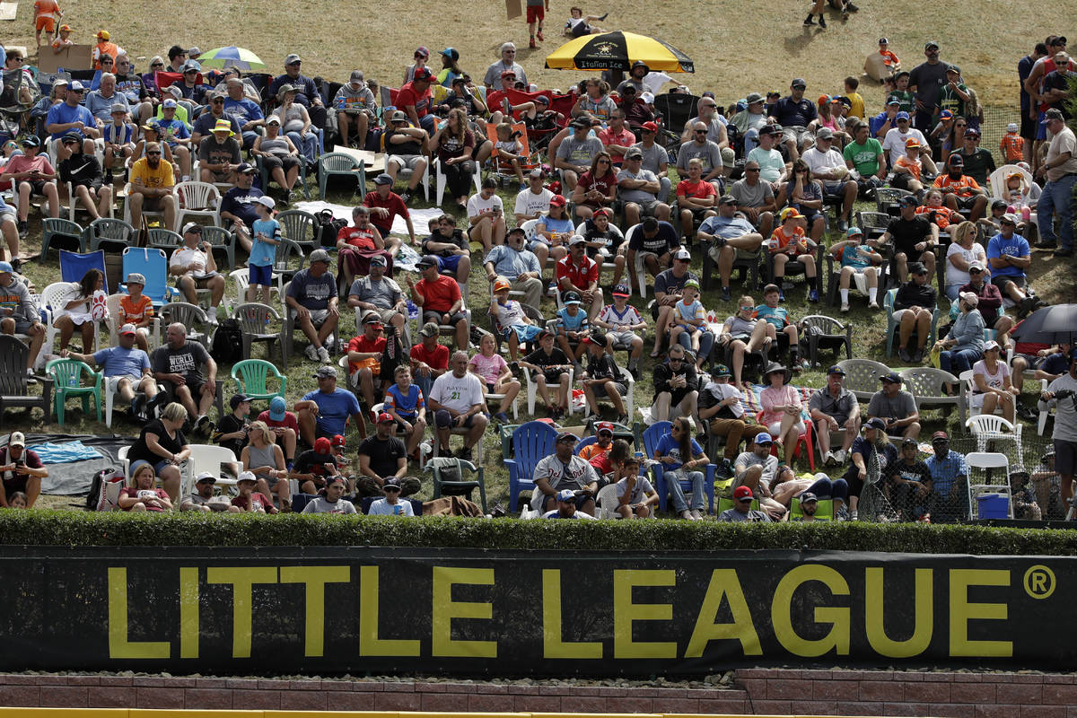In this Aug. 24, 2019, photo, Little League fans watch from the hillside overlooking left field ...