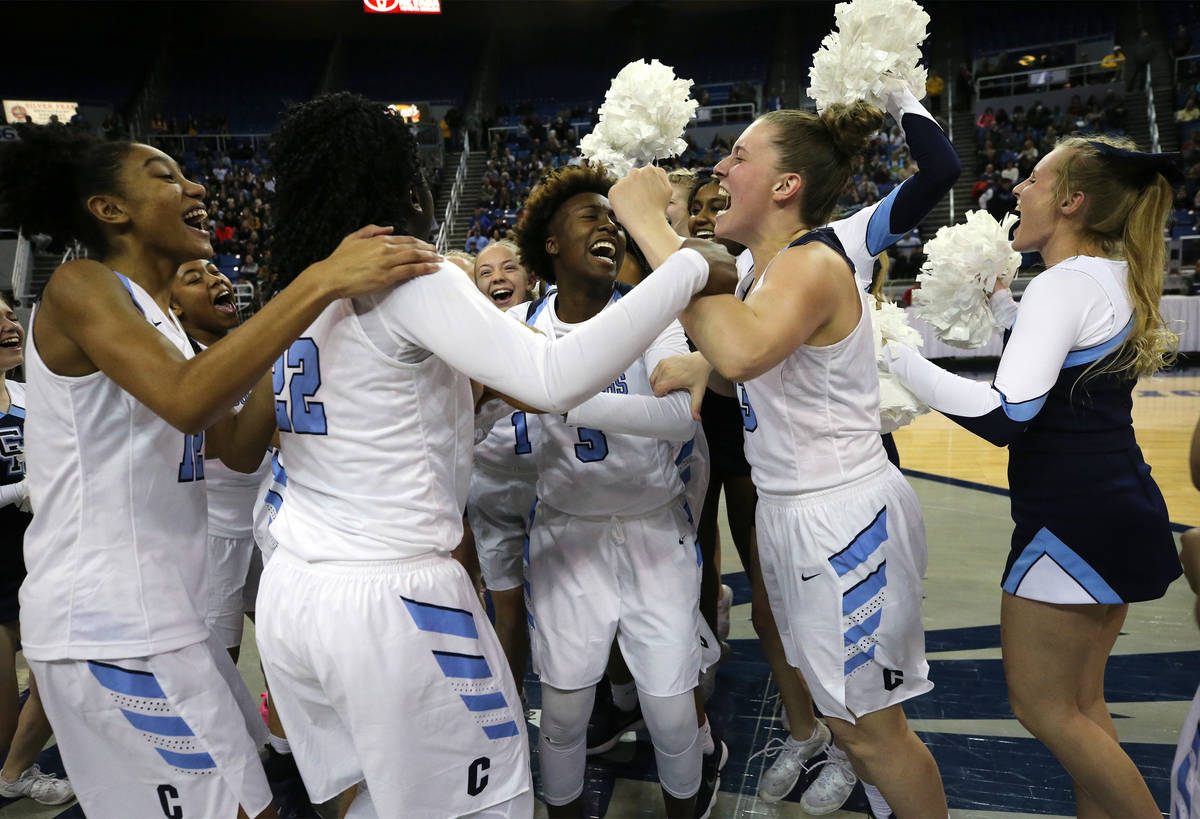 The Centennial Bulldogs celebrate a 74-65 overtime win over Liberty for the NIAA state basketba ...