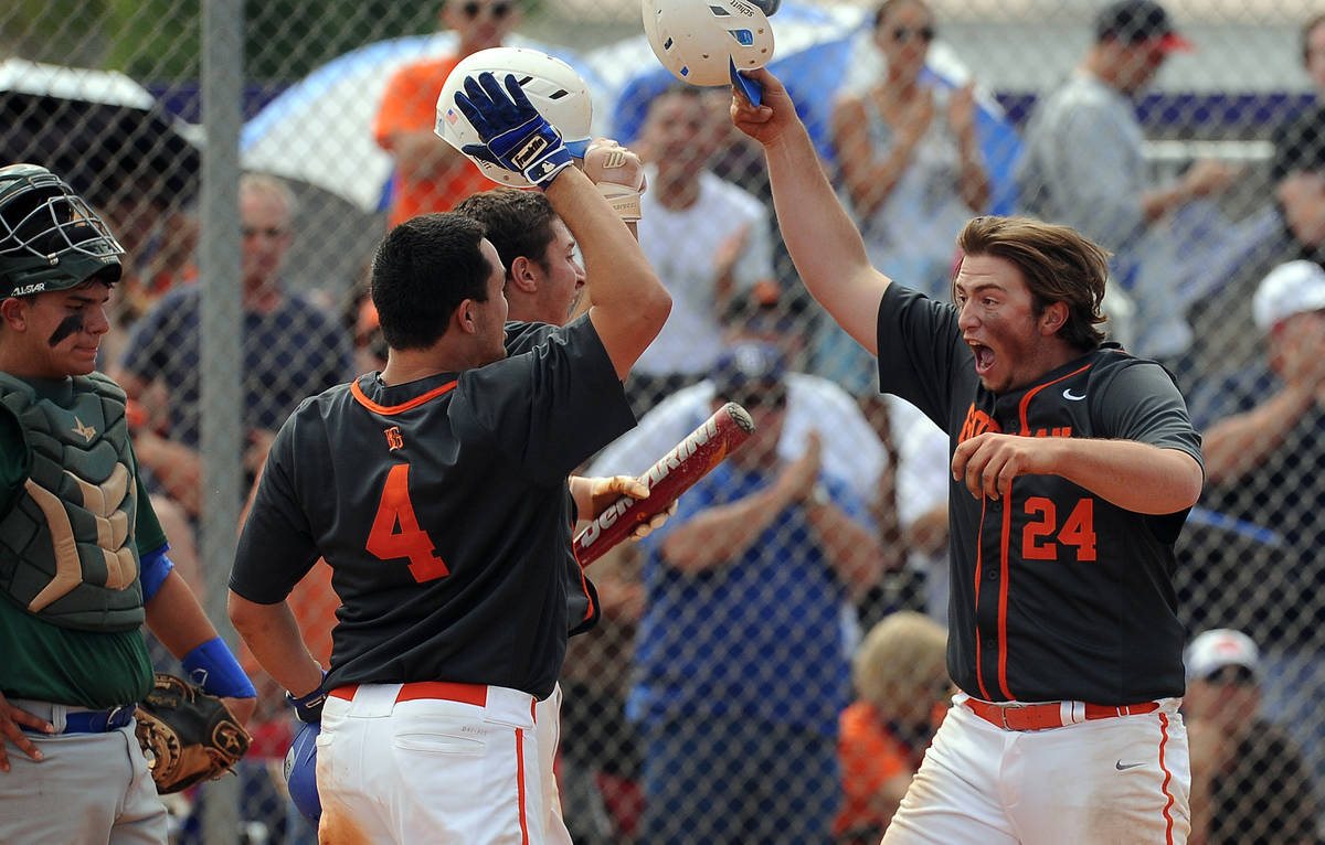 Bishop Gorman first baseman Austin Cram (24) high fives teammates home plate as catcher Ty Burg ...