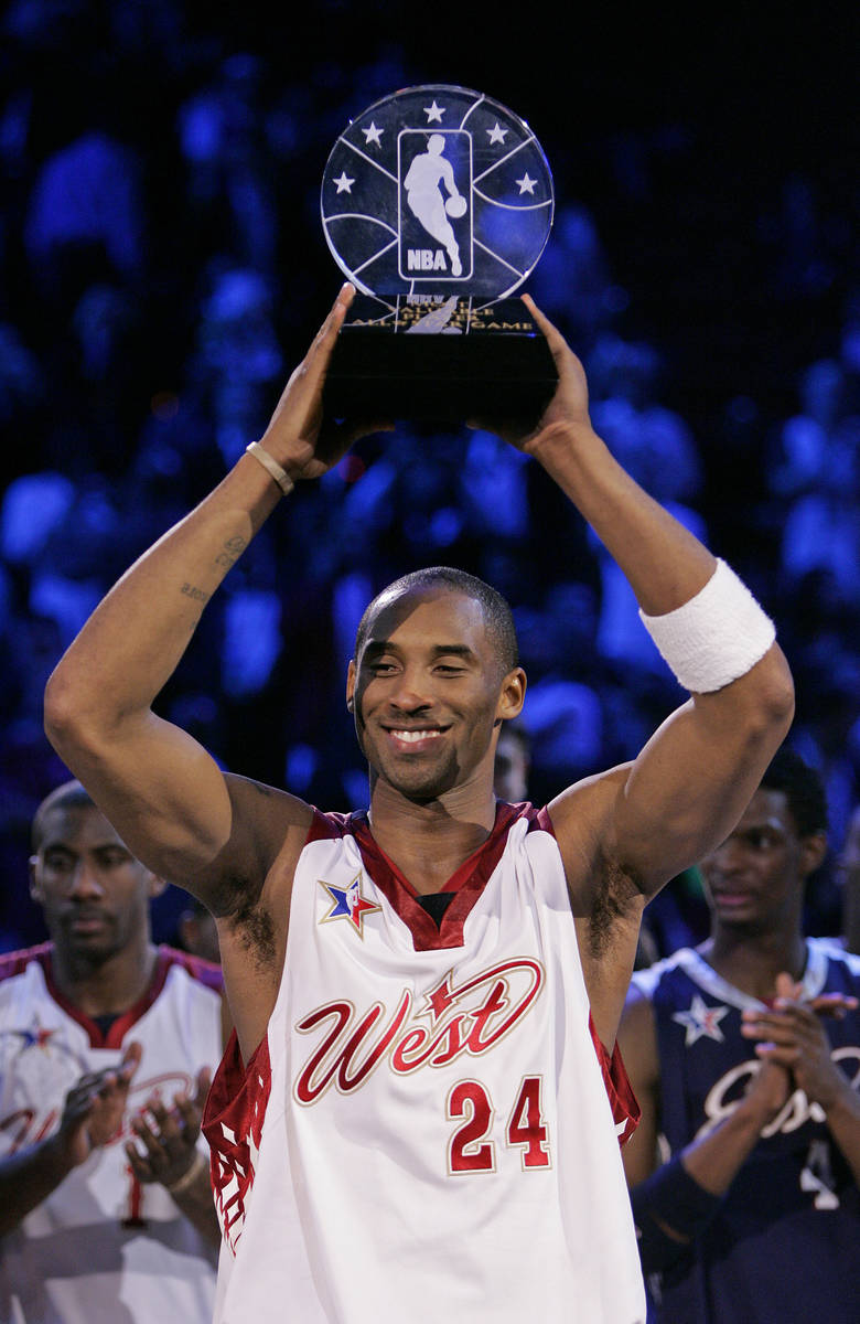 NBA Western Conference player Kobe Bryant holds up the Most Valuable Player trophy after it was ...