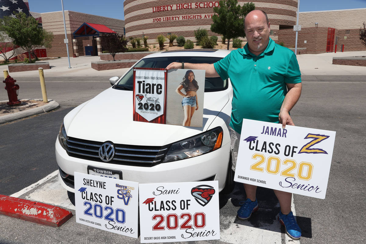 Steve Rosenthal poses with yard signs he makes for high school seniors, at Liberty High School ...