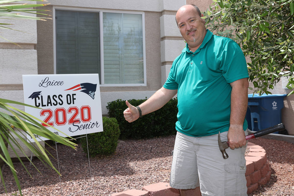 Steve Rosenthal poses after delivering a yard sign to the home of a Liberty High School senior ...