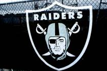 The Raiders logo hangs over a fence surrounding the Oakland Coliseum in Oakland, Calif., on Sun ...