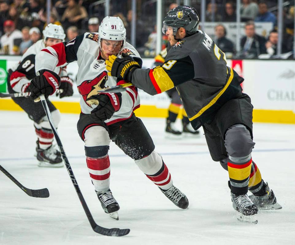 Arizona Coyotes left wing Taylor Hall (91, left) takes a shot from Vegas Golden Knights defense ...