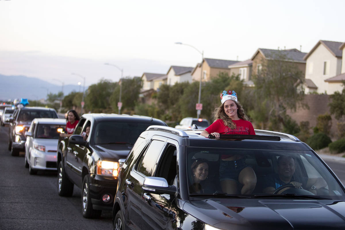 Senior Gracelyn Gattis smiles out her sunroof as a parade of cars pass Coronado High School for ...