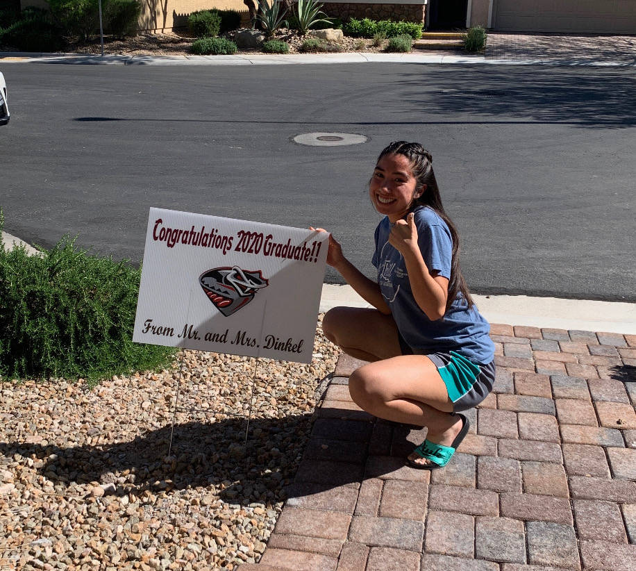 Desert Oasis senior track athlete Katherine Rojas poses with a sign given to her by coaches Jim ...