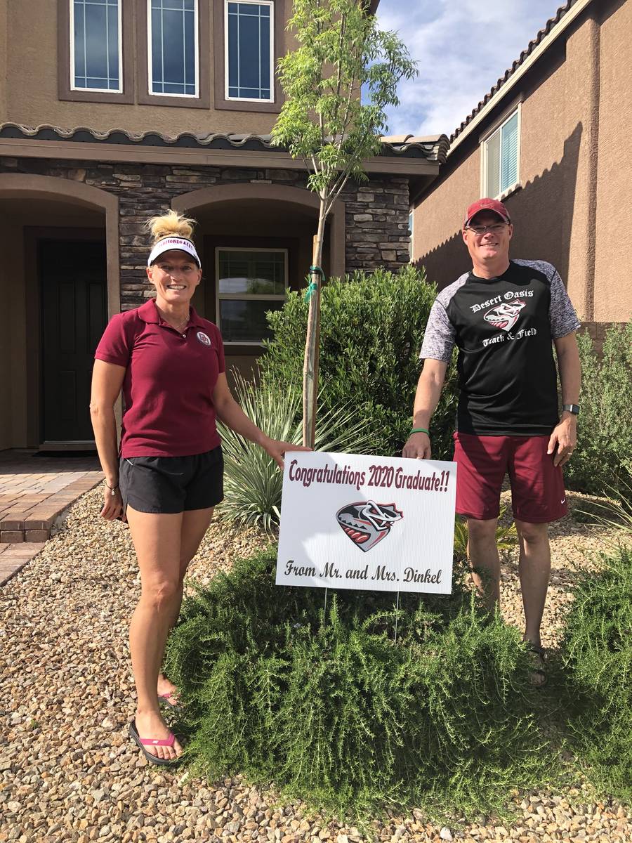 Desert Oasis coaches Jim and Cindy Dinkel pose with a sign they had made for each of their seni ...