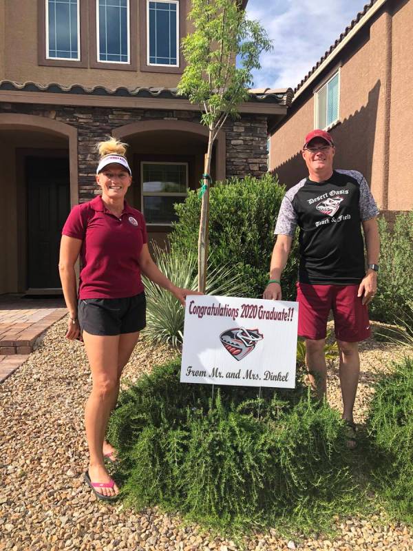 Desert Oasis coaches Jim and Cindy Dinkel pose with a sign they had made for each of their seni ...