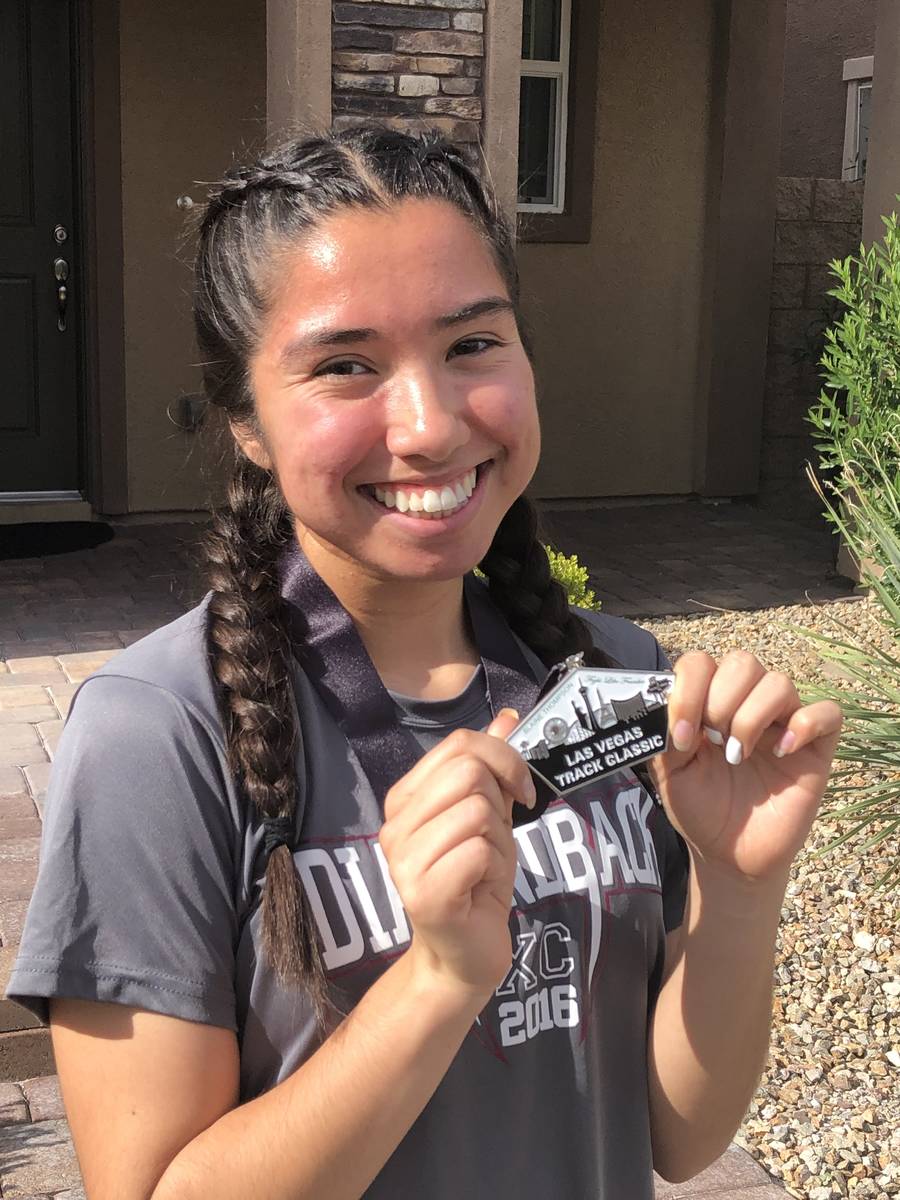 Desert Oasis senior track athlete Katherine Rojas poses with a medal given to her by coach Jim ...