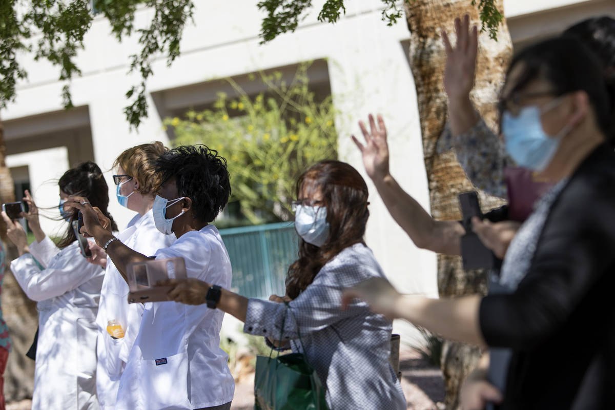 Southwest Medical physicians and nurses wave to a parade of vehicles who drove through to suppo ...