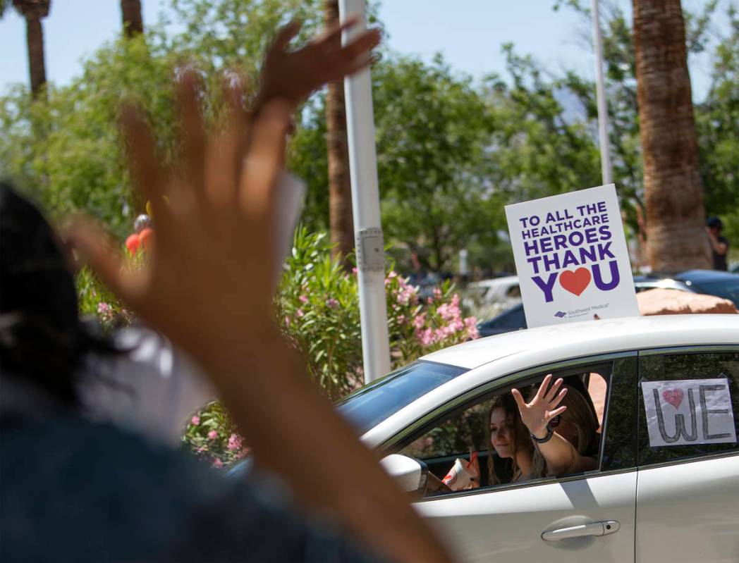 Vehicles drive through to thank Southwest Medical physicians and nurses as the staff waves back ...