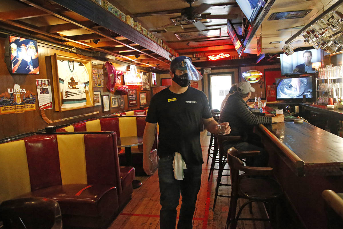 Cheers to You bartender Andrew Lohry wears a mask and face shield after the bar opened Friday m ...