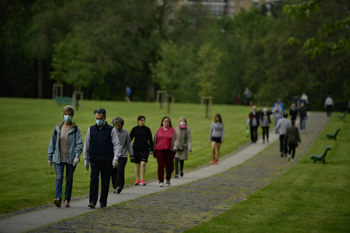 People wearing face masks to protect against coronavirus exercise along Vuelta del Castillo par ...