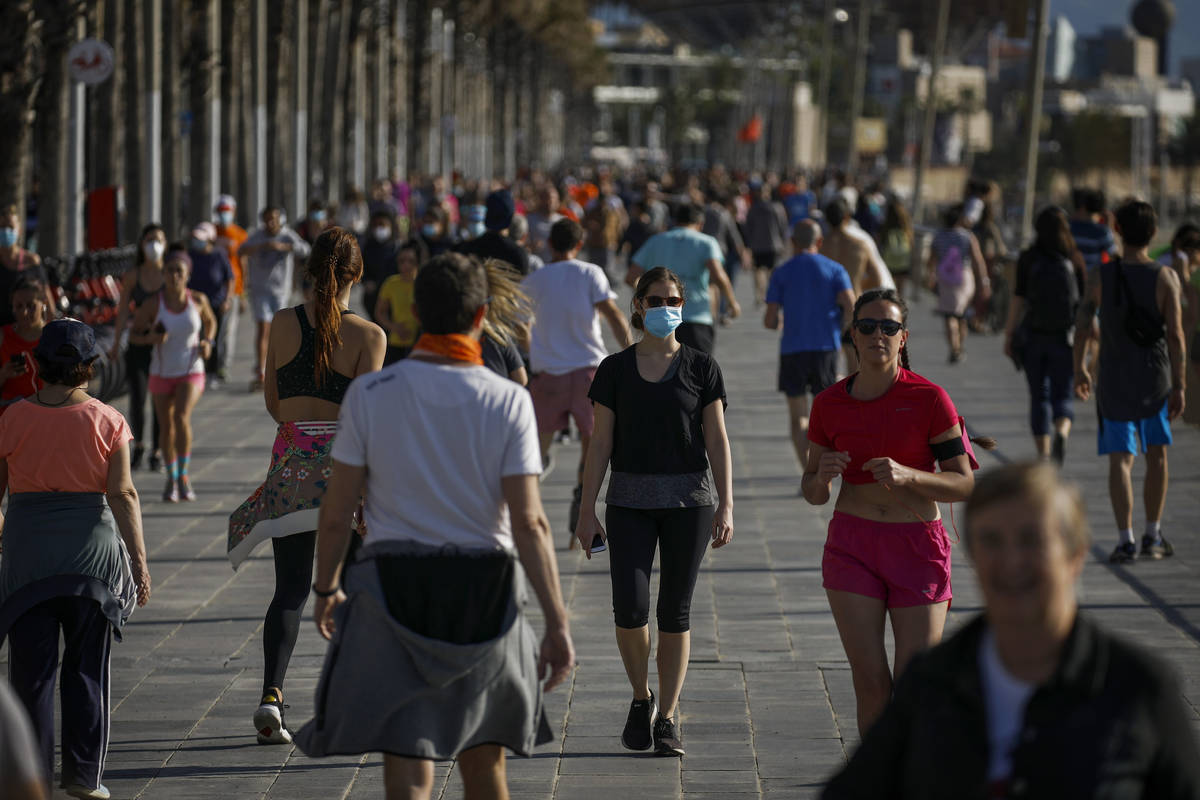 People exercises in a seafront promenade in this photo taken with a telephoto lens in Barcelona ...